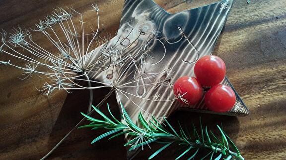 Houten ster met tomaatjes, rozemarijn en gedroogde dille als kerstthema